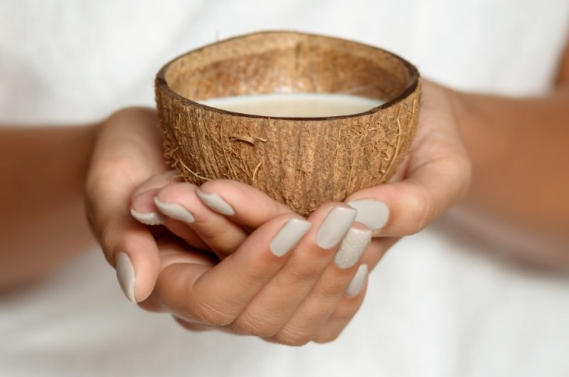 close up woman holding coconut spa salon 1